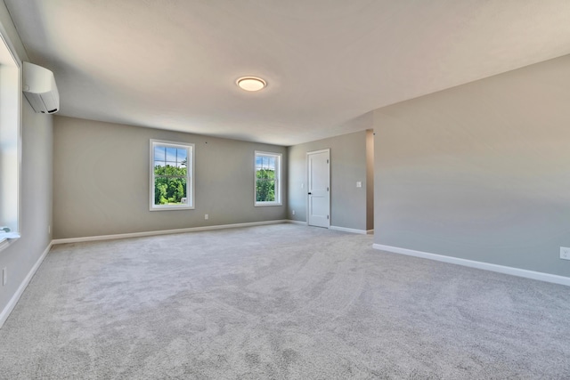 unfurnished room with light colored carpet and an AC wall unit