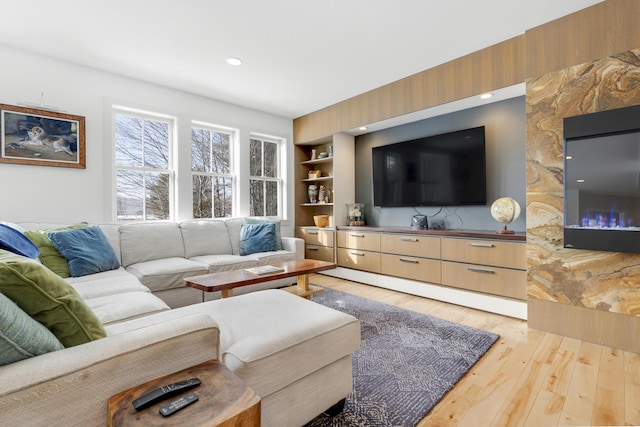 living room featuring built in features and light wood-type flooring