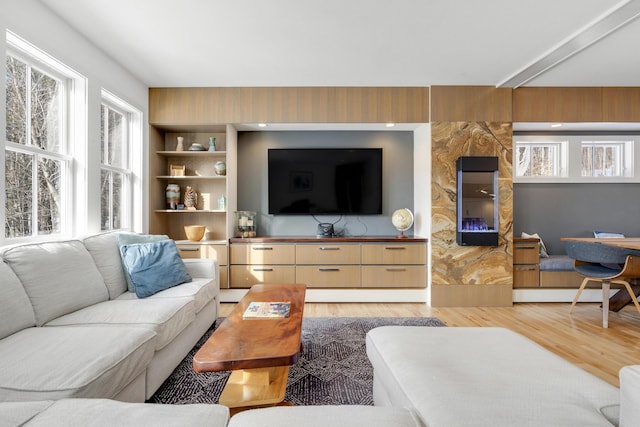 living room with built in features and light hardwood / wood-style floors