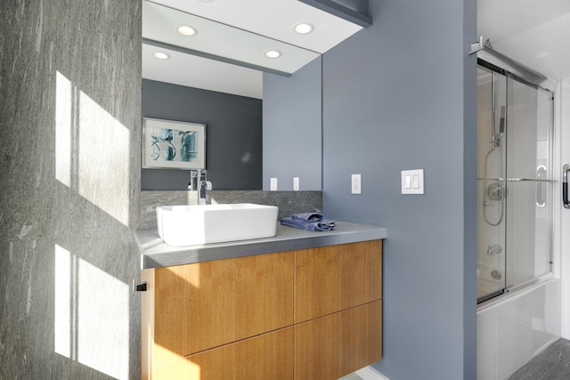 bathroom with vanity and bath / shower combo with glass door