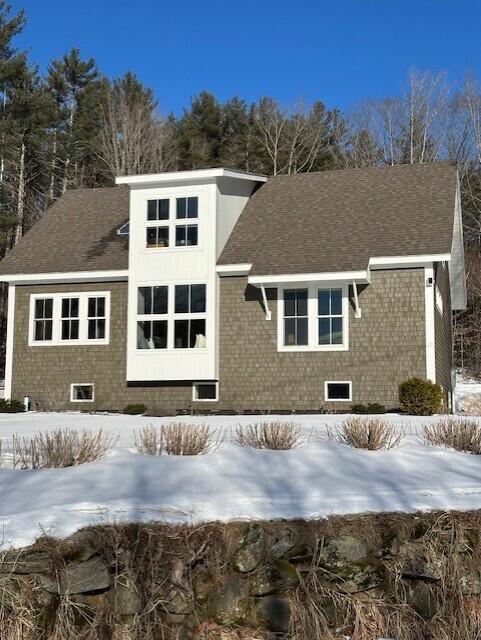 view of snow covered back of property