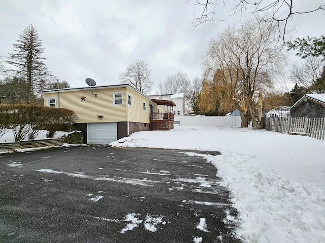 snow covered property featuring a garage