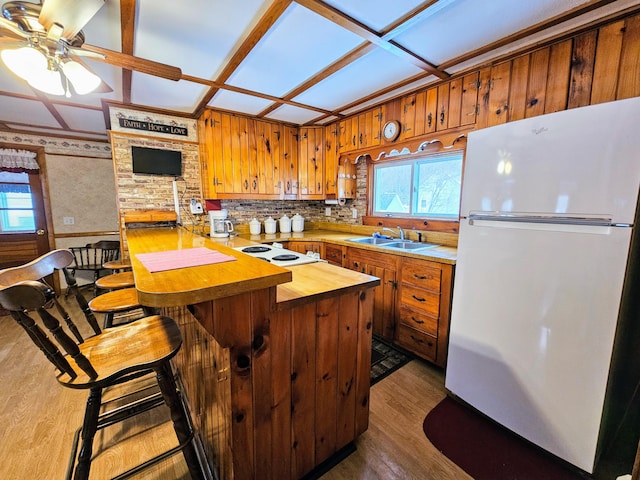 kitchen with ceiling fan, dark hardwood / wood-style floors, a breakfast bar, sink, and white appliances