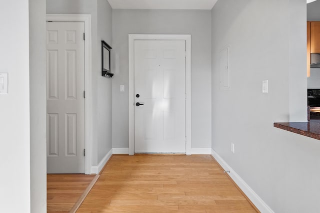 doorway with electric panel and light hardwood / wood-style flooring