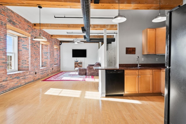 kitchen with brick wall, hanging light fixtures, black appliances, beam ceiling, and sink