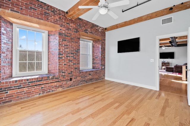 living room featuring beam ceiling, ceiling fan, brick wall, and light hardwood / wood-style floors