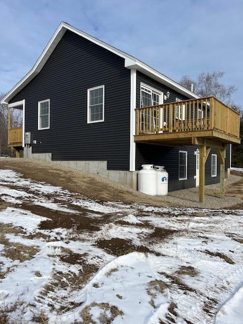 view of snowy exterior with a wooden deck