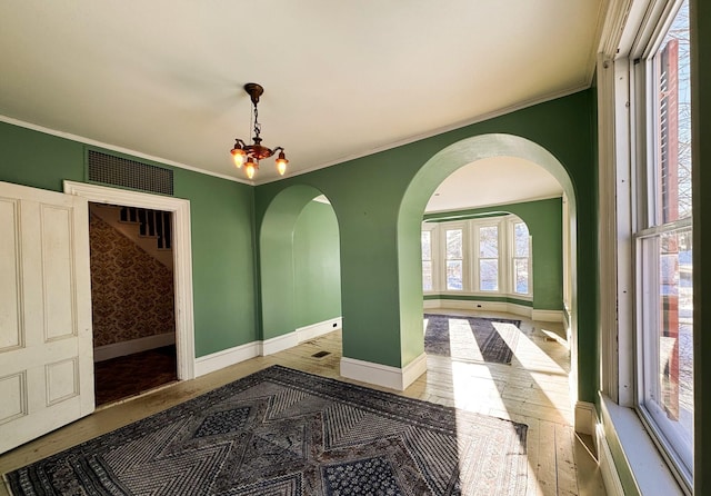 interior space with crown molding, hardwood / wood-style floors, and a chandelier