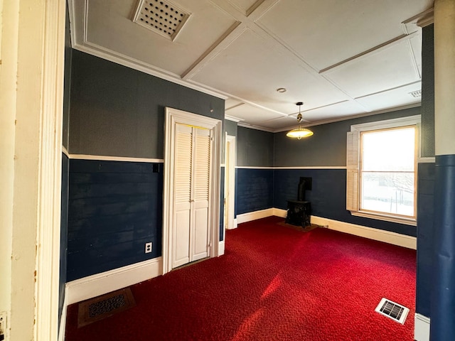 interior space with ornamental molding, carpet floors, and a wood stove