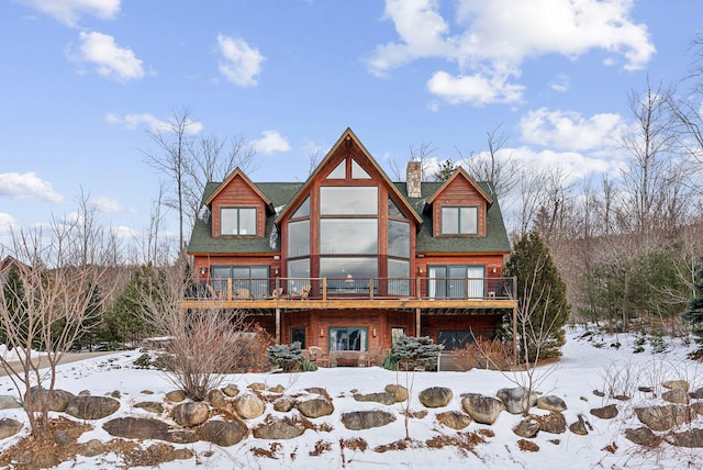 snow covered rear of property featuring a deck