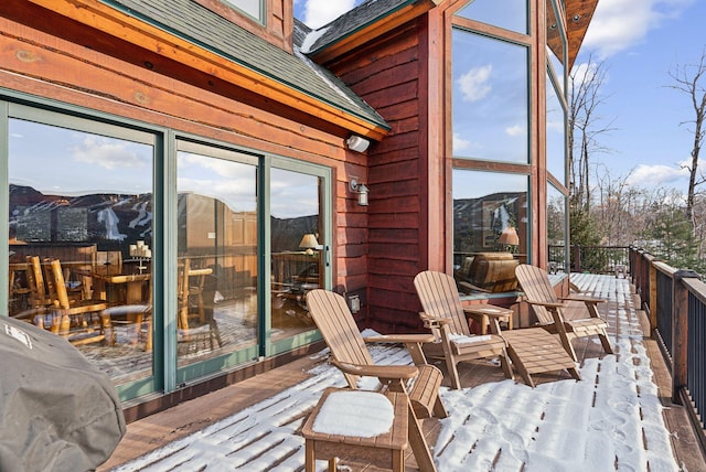 snow covered deck with a mountain view