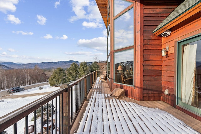 snow covered back of property featuring a mountain view