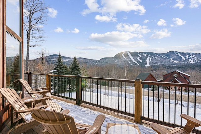 snow covered deck with a mountain view