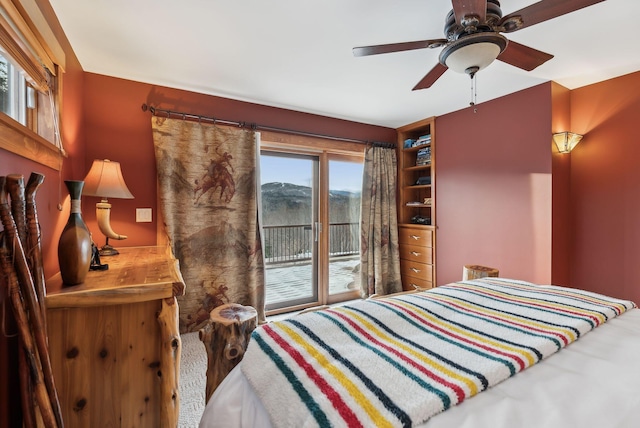 bedroom with ceiling fan, a mountain view, and access to outside