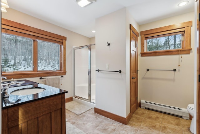 bathroom featuring a baseboard radiator, toilet, a shower with door, and vanity