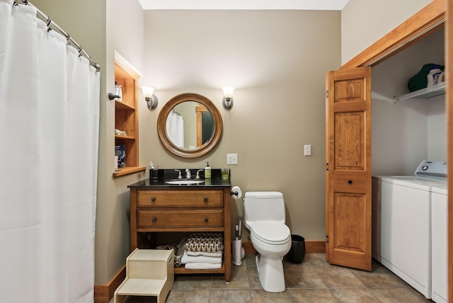 bathroom featuring toilet, washer / clothes dryer, and vanity