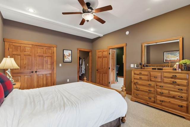 carpeted bedroom featuring ceiling fan and a closet