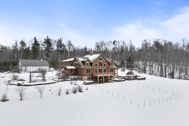 snow covered back of property with a wooden deck