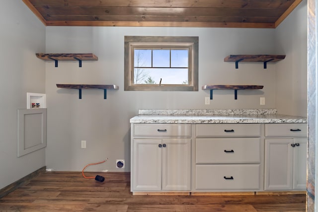 clothes washing area featuring wooden ceiling, dark hardwood / wood-style flooring, hookup for a washing machine, and cabinets