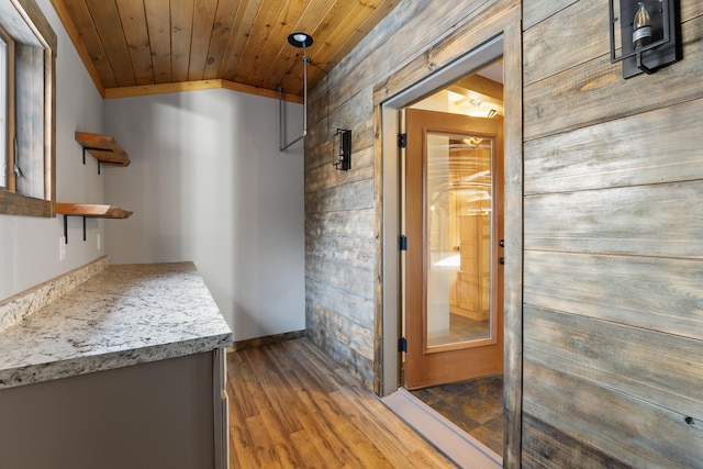 interior space with wooden ceiling, dark hardwood / wood-style flooring, wood walls, and vaulted ceiling