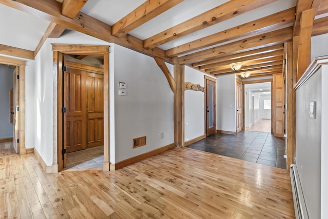 interior space with beam ceiling, a baseboard heating unit, and wood-type flooring