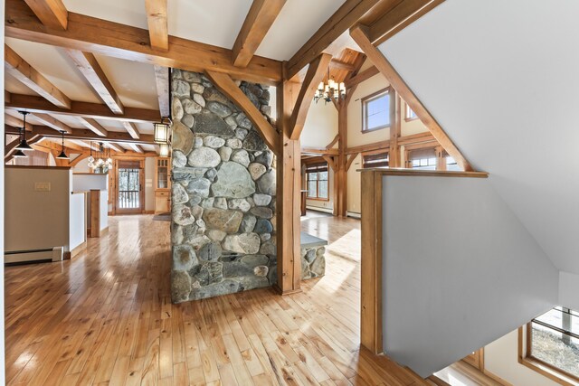 hallway with a baseboard heating unit, a chandelier, beam ceiling, and light hardwood / wood-style floors