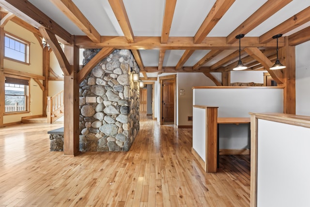 interior space with light hardwood / wood-style flooring and beamed ceiling