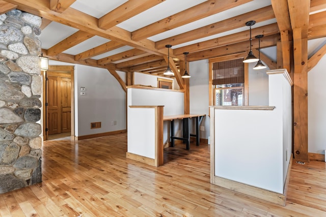 interior space featuring beamed ceiling and light hardwood / wood-style flooring