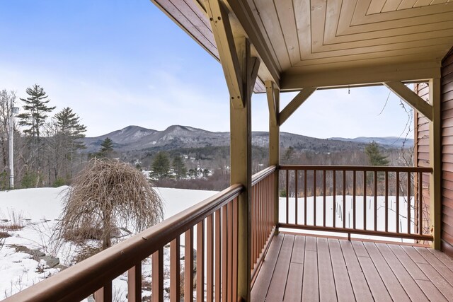 snow covered deck with a mountain view