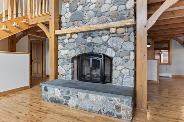 details with hardwood / wood-style flooring, baseboard heating, and a fireplace