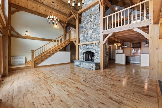 unfurnished living room with high vaulted ceiling, wood ceiling, beamed ceiling, and an inviting chandelier