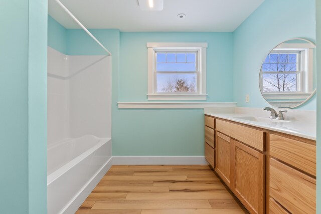 bathroom with shower / bathing tub combination, vanity, a wealth of natural light, and hardwood / wood-style flooring