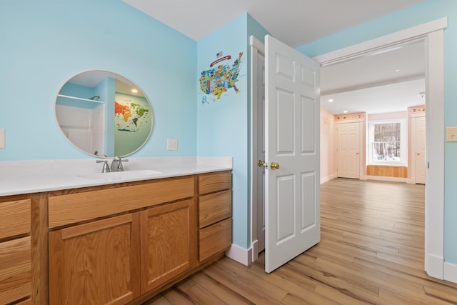 bathroom with a shower, hardwood / wood-style floors, and vanity