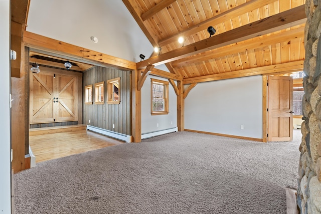 unfurnished living room with beam ceiling, wood ceiling, a barn door, and a baseboard radiator