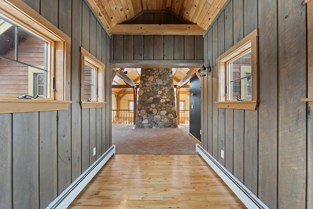 corridor featuring light colored carpet, a baseboard heating unit, lofted ceiling, and wood ceiling