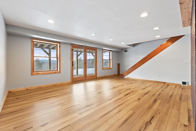 unfurnished living room with plenty of natural light and light hardwood / wood-style flooring