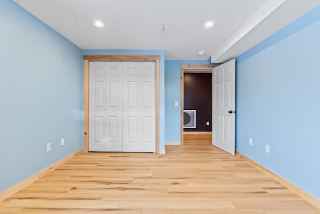 unfurnished bedroom featuring a closet and light hardwood / wood-style flooring