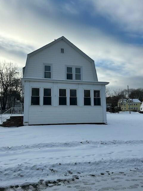 view of snow covered rear of property