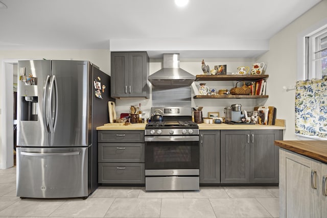 32 Beals Ave, Ellsworth, ME 04605 - kitchen featuring stainless steel appliances, wall chimney range hood, wood counters, light tile patterned floors, and gray cabinetry