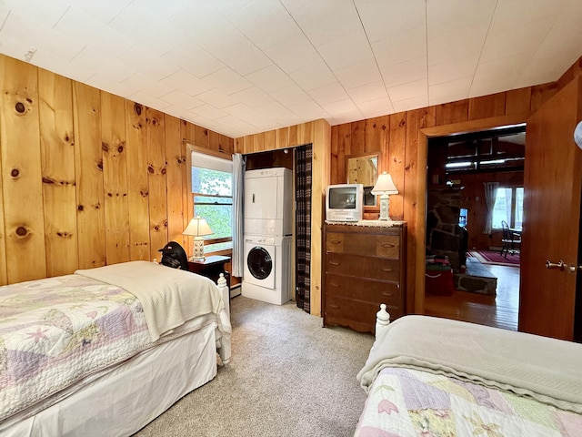 37 Treasure Island Rd, Shapleigh, ME 04076 - bedroom with stacked washing machine and dryer, wood walls, and light carpet