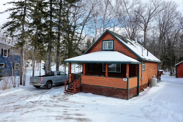 snow covered property featuring covered porch