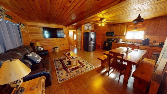 living room with ceiling fan, wooden ceiling, light hardwood / wood-style floors, and wood walls