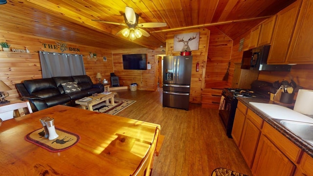 kitchen featuring wood ceiling, black appliances, light hardwood / wood-style floors, and wood walls