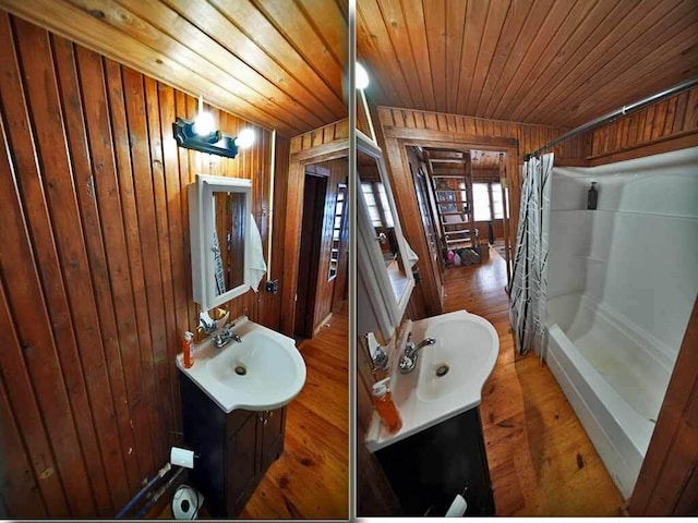 bathroom with shower / bath combination with curtain, wooden ceiling, vanity, and wood walls