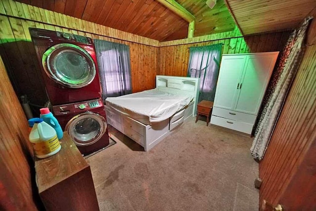 bedroom featuring stacked washing maching and dryer, lofted ceiling, light colored carpet, and wood walls