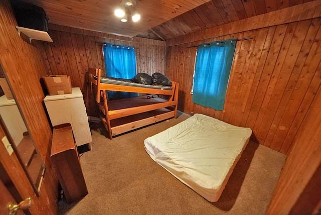 carpeted bedroom with washer / dryer, wood ceiling, and wood walls