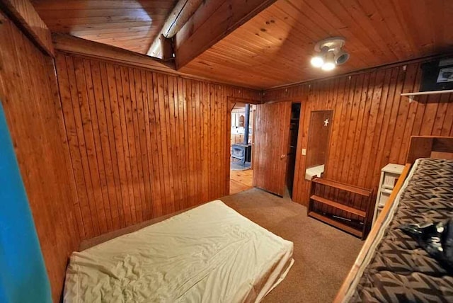 bedroom with carpet floors, wooden ceiling, and wood walls