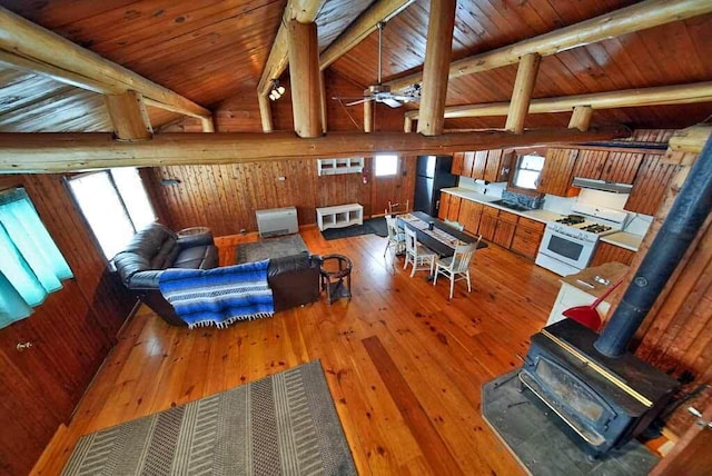 living room featuring wood ceiling, vaulted ceiling with beams, wood-type flooring, and a wood stove