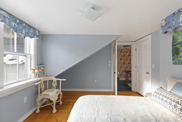 bedroom with multiple windows and hardwood / wood-style floors