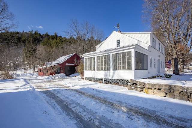 view of snow covered exterior featuring a sunroom